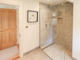 A bathroom with a glass shower and a wooden door at Fern Bank in Penrith