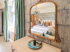 A bedroom with a large mirror and decorative elements at Fern Bank in Penrith