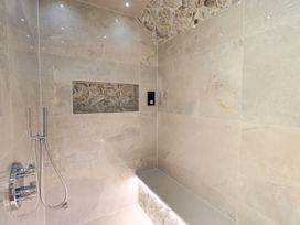 A shower with tiled walls and a shelf at Fern Bank in Penrith