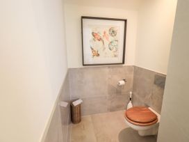 A bathroom with a toilet and artwork at Fern Bank in Penrith