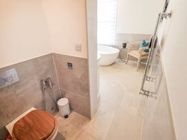 A bathroom with a toilet and a bath tub at Fern Bank in Penrith