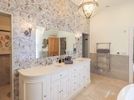 A bathroom with a double sink and large mirror at Fern Bank in Penrith