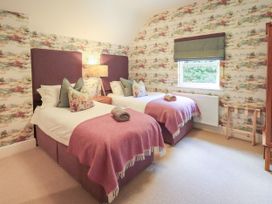 A bedroom with two single beds and a window at Fern Bank in Penrith
