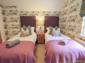 A bedroom with two beds and a nightstand at Fern Bank in Penrith