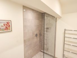 A shower with glass doors in a bathroom at Fern Bank in Penrith