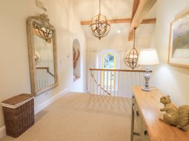 A hallway with a mirror, table, and light fixtures at Fern Bank in Penrith