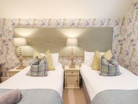 A bedroom with twin beds and bedside tables at Fern Bank in Penrith
