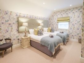 A bedroom with twin beds and decorative wallpaper at Fern Bank in Penrith