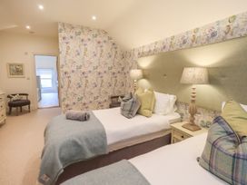 A bedroom with two beds and lamps at Fern Bank in Penrith