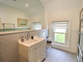 A bathroom with a sink, toilet, and mirror at Fern Bank in Penrith
