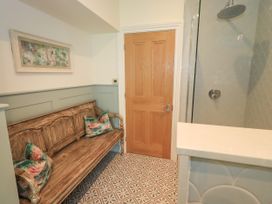 A bathroom featuring a wooden bench and shower at Fern Bank in Penrith