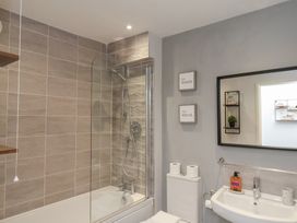 A bathroom with a bathtub shower combination sink toilet and mirror at Coastguards View Whitby