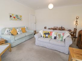 A living room with two sofas and a dining table in the background at Seawinds 2a in Rhos-On-Sea
