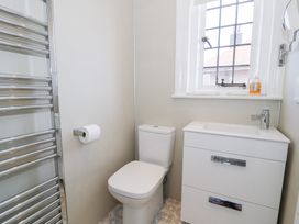 A bathroom with a toilet sink cabinet window and towel radiator at Seawinds 2a in Rhos-On-Sea