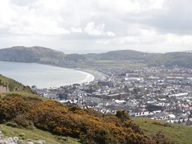 A coastal town with a bay and hills in the background with buildings and greenery at Seawinds in Rhos-On-Sea
