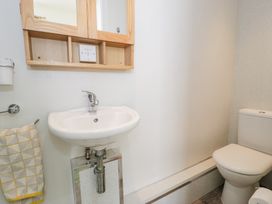 A bathroom with a sink towel rack mirror cabinet and toilet at Seawinds in Rhos-On-Sea