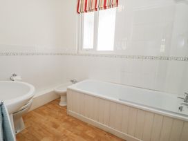 A bathroom with a bathtub sink bidet and window at Seawinds in Rhos-On-Sea
