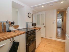 A kitchen with a stove microwave wooden countertops and utensils at Saltwater Cottage in Babbacombe