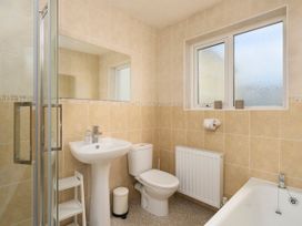 A bathroom with a pedestal sink toilet a shower enclosure and a bathtub at Saltwater Cottage in Babbacombe