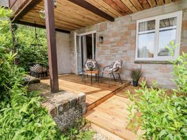 A wooden deck with chairs and a table at Lavender Lodge in St. Ann's Chapel, Cornwall