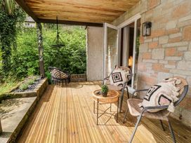 An outdoor area with hanging chair and two chairs at Lavender Lodge, St. Ann's Chapel, Cornwall