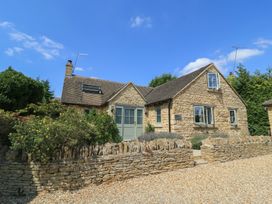 A house with stone walls and a gravel drive at 12 Manor Farm Close Kingham