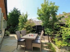 A garden with a dining set on a patio at 12 Manor Farm Close Kingham