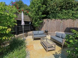 A garden with outdoor seating and a coffee table at 12 Manor Farm Close in Kingham