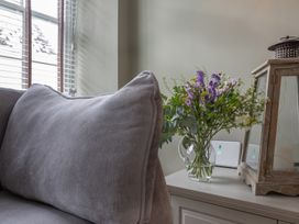A living room with a couch and flowers on a table at George House in Dartmouth