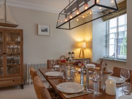 A dining room with a wooden table and glasses at George House in Dartmouth