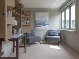 A snug with two armchairs and a shelving unit at George House in Dartmouth