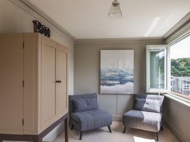 A sitting room with two armchairs and a cabinet at George House in Dartmouth