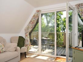 A living room with glass doors opening to a balcony with table and chairs at 60 Valley Lodge Callington near Gunnislake