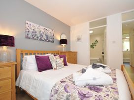 A bedroom with a double bed with purple pillows and floral bed runner at 60 Valley Lodge in Callington near Gunnislake