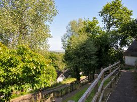 A pathway with wooden fence beside a house and trees at 60 Valley Lodge Callington near Gunnislake