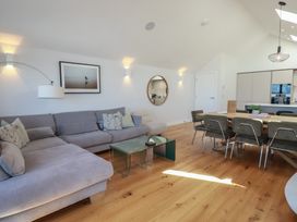 A living room with a sofa and dining table at Porth Cove in Porth