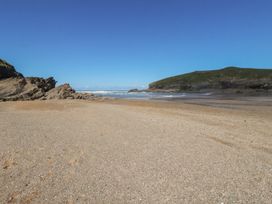 A beach with sand and rocks at Porth Cove in Porth