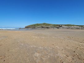 A beach with sand and ocean waves at Porth Cove in Porth