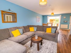 A living room with a sofa and coffee table at Cae Berllan in Mynytho near Pwllheli