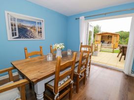 A dining room with a table and chairs at Cae Berllan Mynytho near Pwllheli