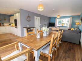 A dining room with a table and chairs at Cae Berllan Mynytho near Pwllheli