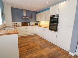 A kitchen with cabinets and appliances at Cae Berllan in Mynytho near Pwllheli