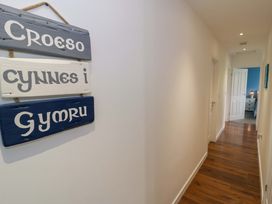 A hallway with a sign and a door leading to a room at Cae Berllan in Mynytho near Pwllheli