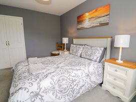 A bedroom with a bed and bedside tables at Cae Berllan in Mynytho near Pwllheli