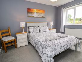 A bedroom with a bed and bedside tables at Cae Berllan in Mynytho near Pwllheli
