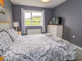 A bedroom with a bed and television at Cae Berllan in Mynytho near Pwllheli