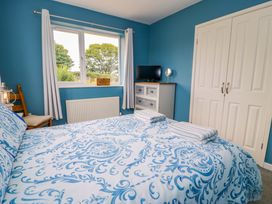 A bedroom with a bed and television at Cae Berllan Mynytho near Pwllheli