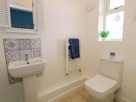 A bathroom with sink, toilet, and radiator at Cae Berllan Mynytho near Pwllheli