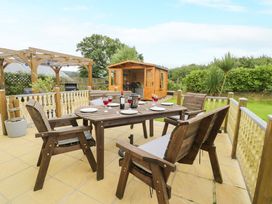A table with chairs and glasses in a garden at Cae Berllan Mynytho near Pwllheli