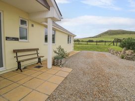 An outdoor area with a bench and gravel at Cae Berllan in Mynytho near Pwllheli